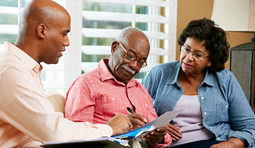 couple completing paperwork with a professional advisor